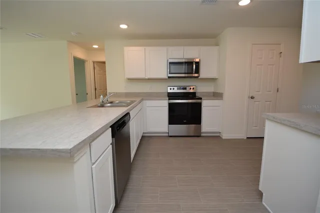 a kitchen with stainless steel appliances a sink stove and microwave