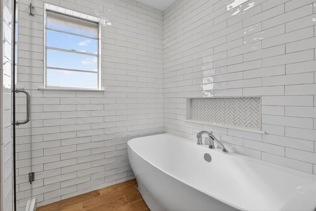 7117 Serrano Drive Benbrook, TX 76126 - Photo 19 of 26 Bathroom featuring tile walls, a soaking tub, and a shower stall