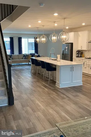 a open kitchen with stainless steel appliances refrigerator stove dining table and chairs