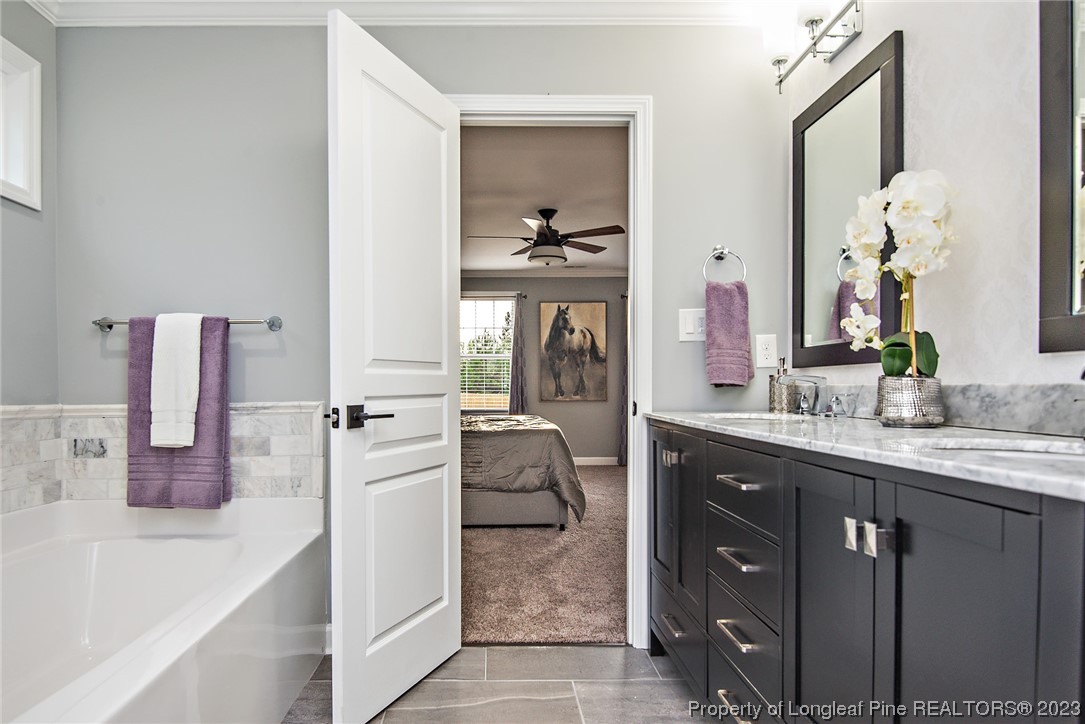 341 Solomon Drive Cameron, NC 28326 - Photo 11 of 21 a en suite bathroom with a granite countertop sink and a mirror