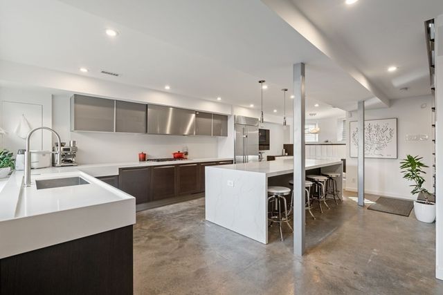a kitchen with kitchen island a sink and a stove top oven