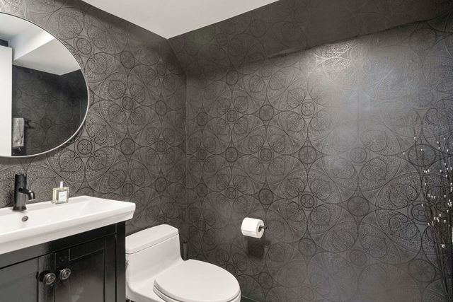 a bathroom with a toilet sink and mirror