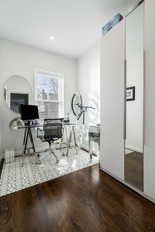 a view of a livingroom with wooden floor and a refrigerator