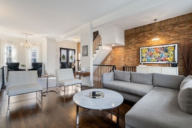 a living room with furniture and a dining table with wooden floor
