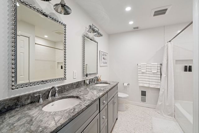 a patio with table and chairs and potted plants