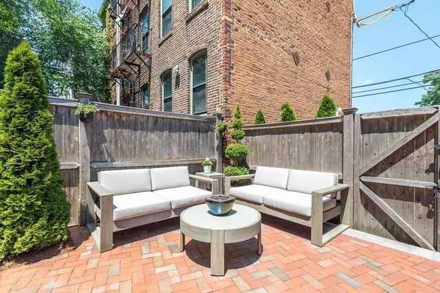 a view of a roof deck with two couches and wooden floor