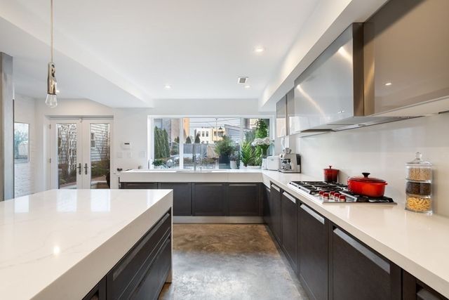 a kitchen with stainless steel appliances a sink window and cabinets