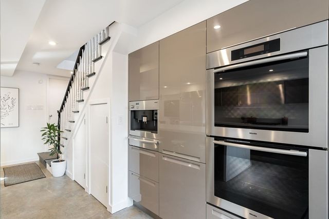 a kitchen with granite countertop white cabinets and stainless steel appliances
