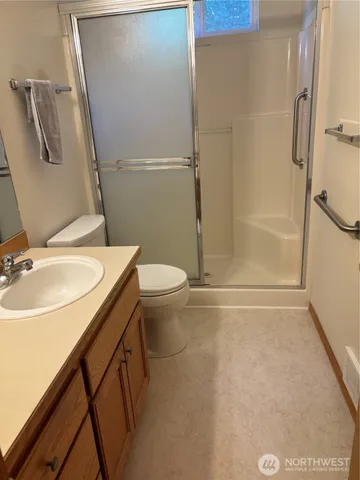 a bathroom with a sink a toilet and shower