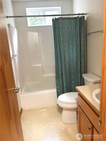 a bathroom with a toilet and a shower curtain