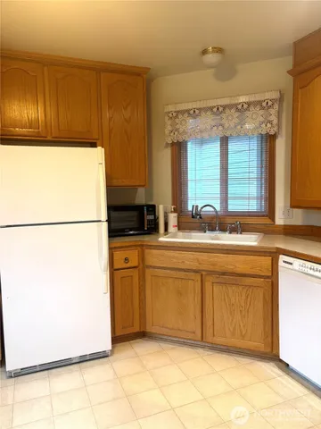 a kitchen with stainless steel appliances granite countertop a refrigerator a sink and a stove