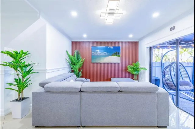a living room with furniture potted plant and a window