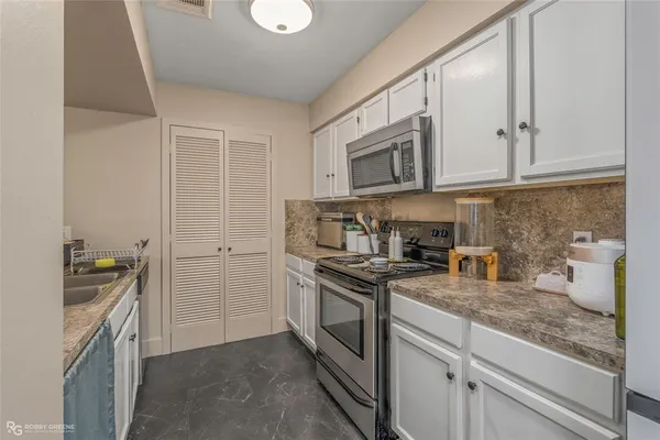 a kitchen with a sink stove and cabinets