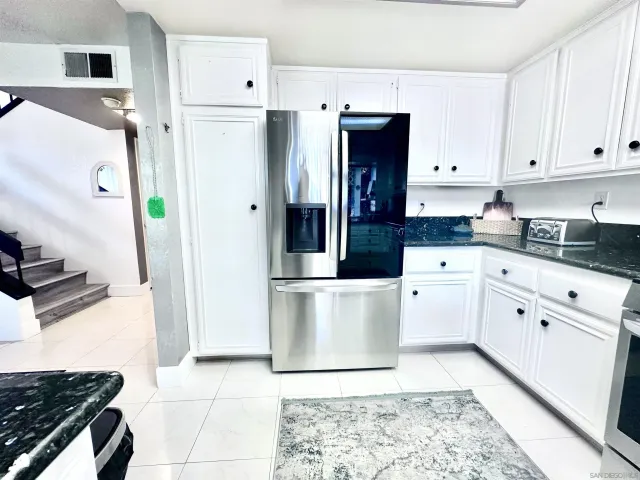 a kitchen with stainless steel appliances a refrigerator sink and cabinets