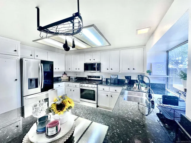 a kitchen with stainless steel appliances granite countertop a sink dishwasher stove top oven and cabinets with wooden floor