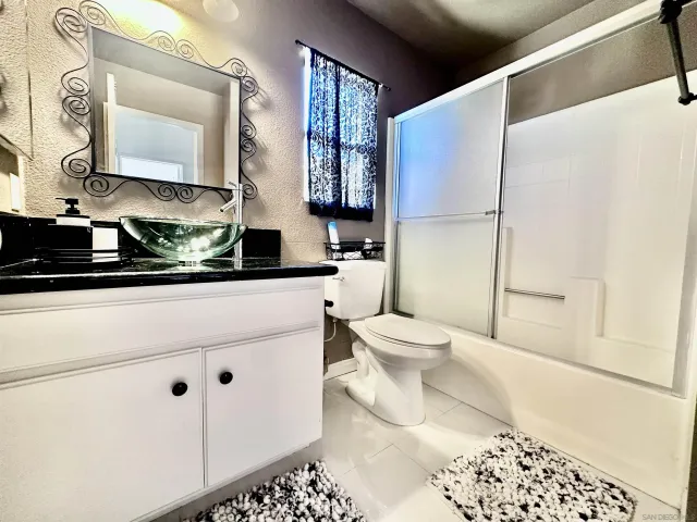 a bathroom with a sink a toilet and mirror