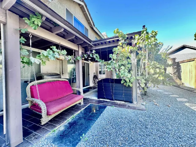 a view of a backyard with table and chairs potted plants