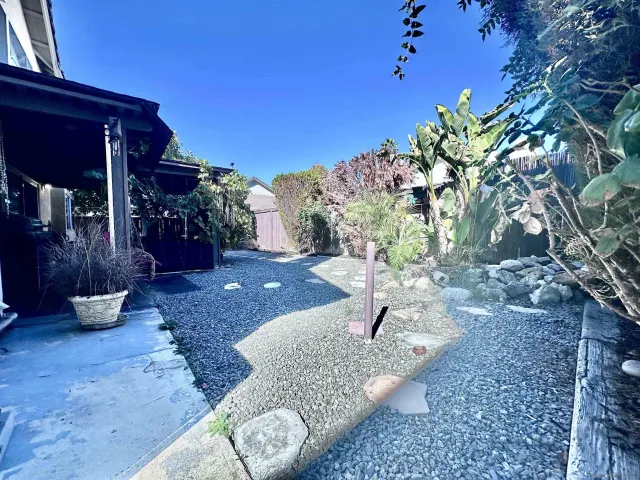 a view of a backyard with table and chairs potted plants