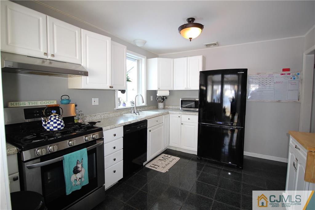 21 Lancaster Road Colonia, NJ 07067 - Photo 5 of 26 a kitchen with stainless steel appliances granite countertop a stove a refrigerator and a microwave