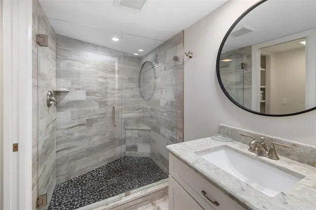 a bathroom with a granite countertop sink a toilet and shower