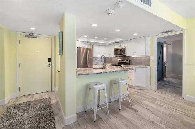 a kitchen with stainless steel appliances granite countertop a refrigerator and a sink