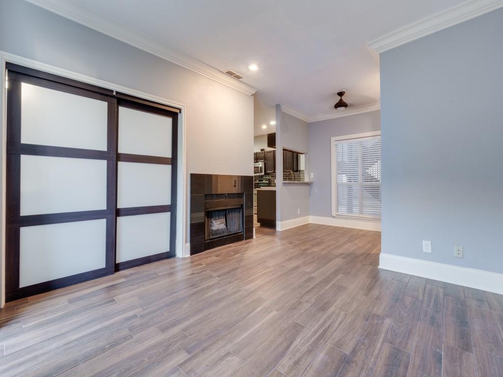 4221 Cole Avenue, Unit 103 Dallas, TX 75205 - Photo 4 of 17 a view of empty room with wooden floor and fireplace