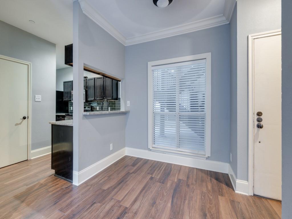 4221 Cole Avenue, Unit 103 Dallas, TX 75205 - Photo 5 of 17 an empty room with wooden floor and a kitchen