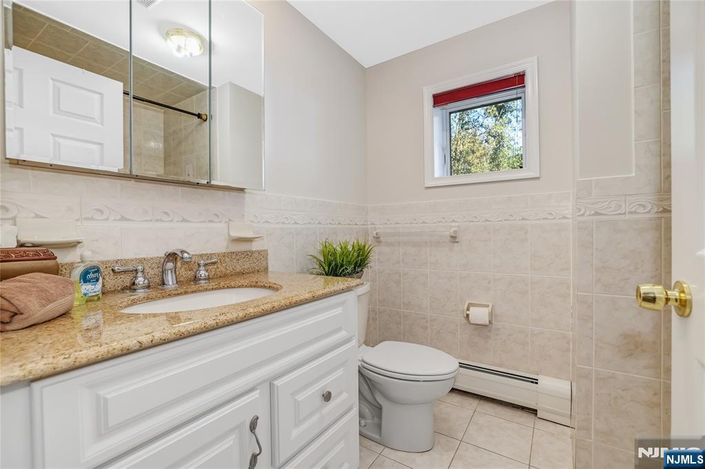 4 Maple Avenue Waldwick, NJ 07463 - Photo 27 of 34 a bathroom with a granite countertop toilet sink and mirror