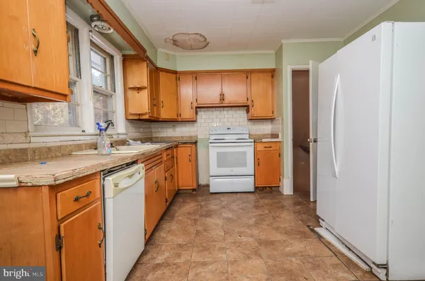 a kitchen with granite countertop cabinets stainless steel appliances a sink and a window