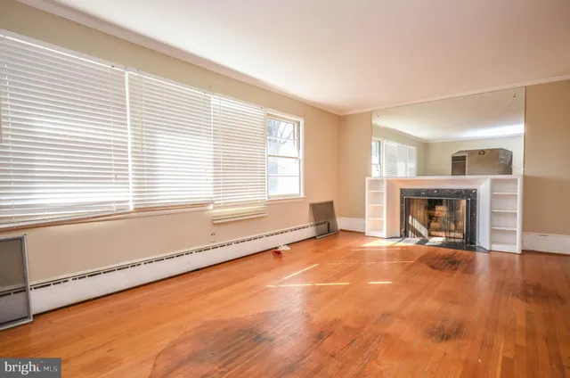 a view of an empty room with a window and fireplace