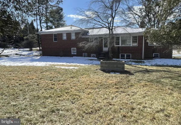 a view of a car parked in front of a house with a big yard