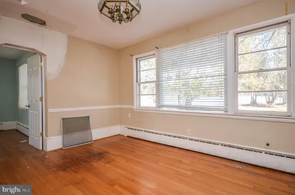 an empty room with wooden floor and fireplace