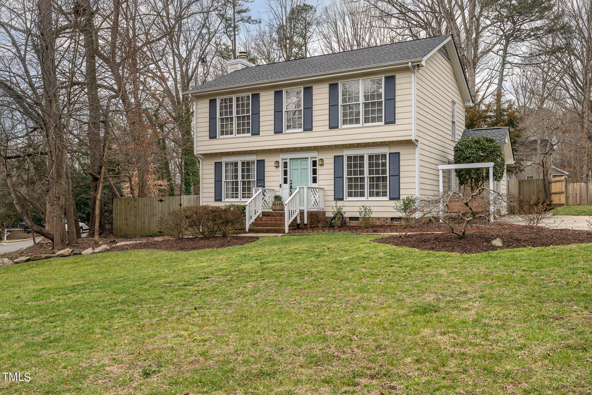 a front view of a house with a garden and trees