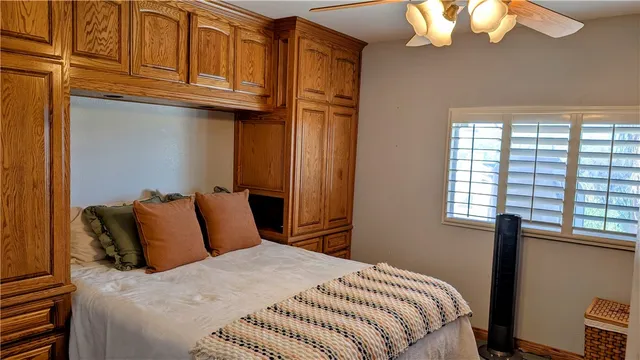 a bedroom with a bed cabinets and a window