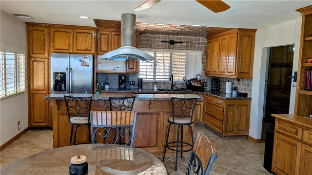 a kitchen with stainless steel appliances granite countertop a stove a sink and a refrigerator