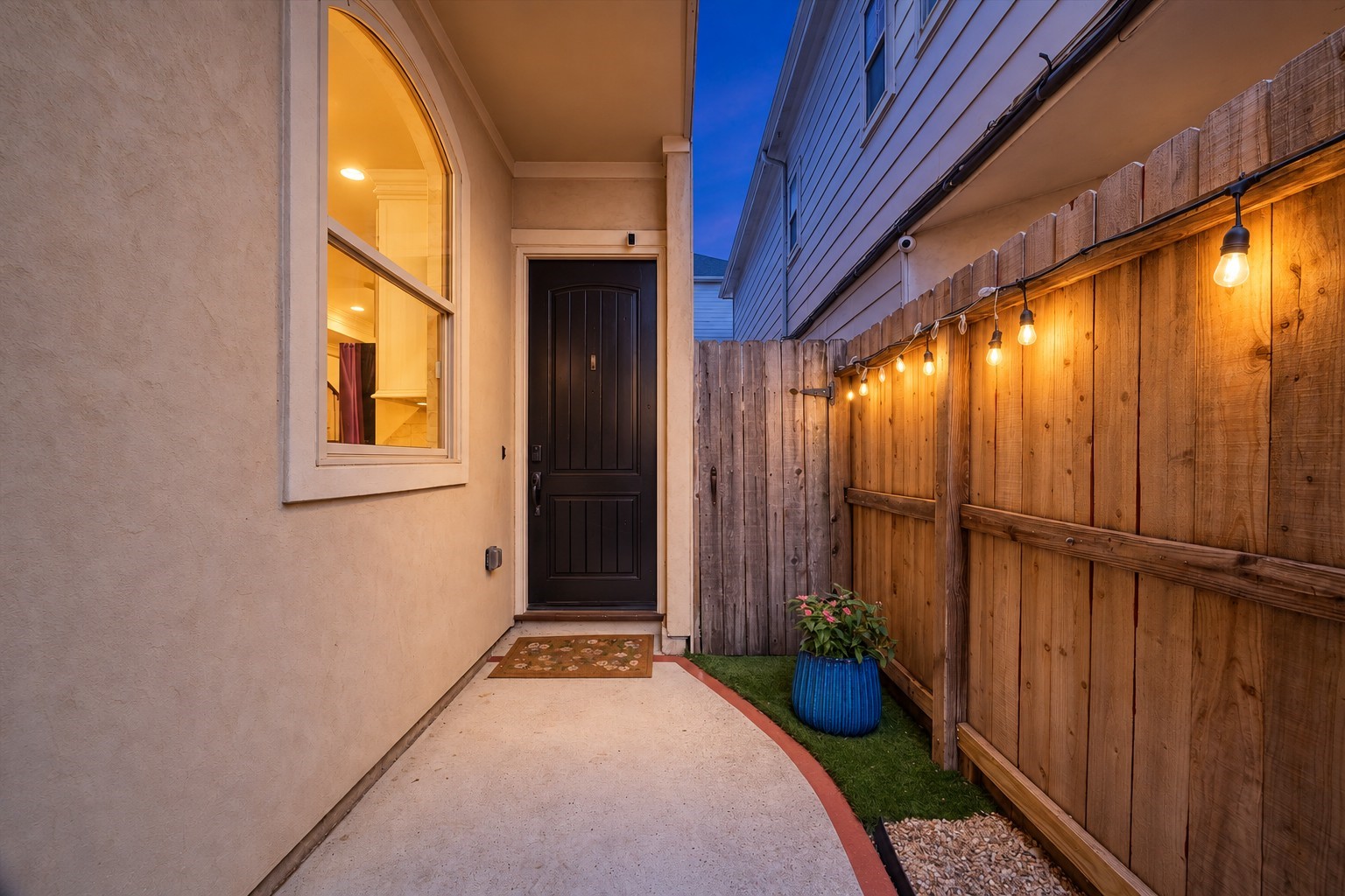 5334 Inker Street Houston, TX 77007 - Photo 4 of 39 The inviting front entryway is discreetly tucked behind a secure private gate, perfectly shielding the home from street views to offer an enhanced sense of seclusion and serenity. This charming transition space provides an ideal, welcoming atmosphere for greeting guests, blending essential privacy with a sophisticated aesthetic that sets a warm and elegant tone for the entire residence.