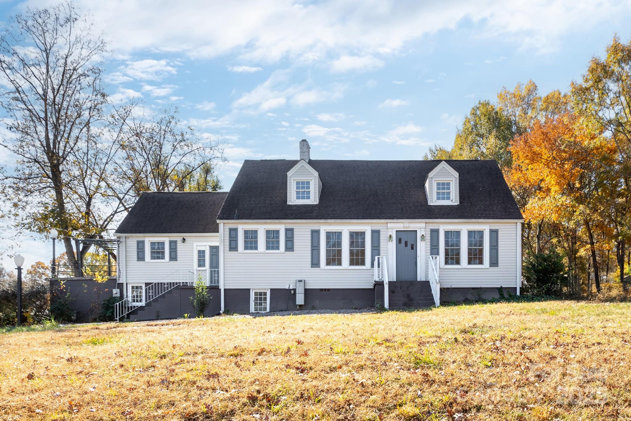 a view of a white house with a large tree