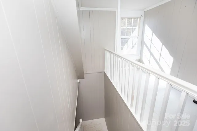 a view of staircase with wooden floor and white walls