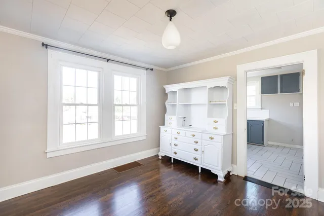 a view of a bedroom with wooden floor closet and windows