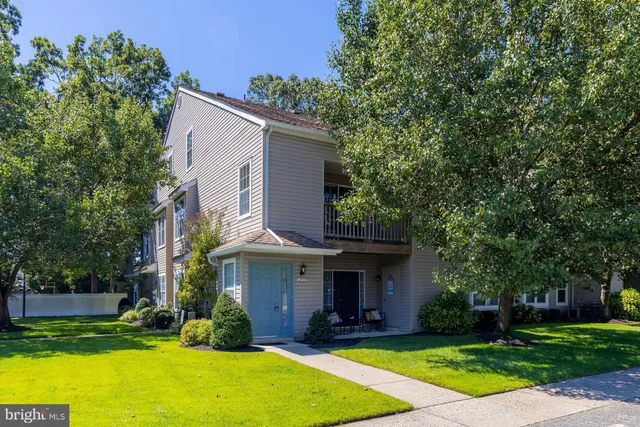 a front view of a house with yard and trees