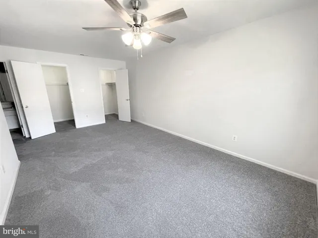 an empty room with a ceiling fan and a window
