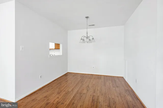 a view of a room with wooden floor and an entryway