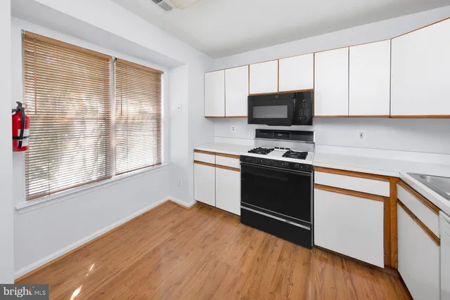 a kitchen with granite countertop a stove a sink and a microwave