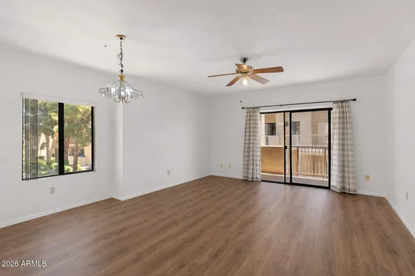 an empty room with chandelier fan