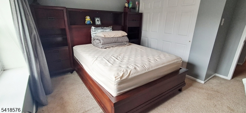 15 Andover Circle Princeton, NJ 08540 - Photo 13 of 16 a bed sitting in a bedroom next to a wooden cabinet