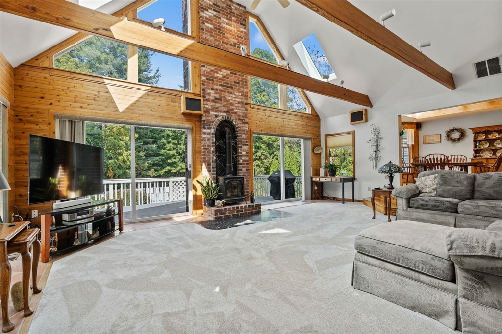 3 Summit Groton, MA 01450 - Photo 20 of 38 a living room with furniture a flat screen tv and floor to ceiling windows