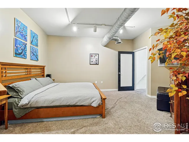 a bedroom with a bed and a painting on the wall