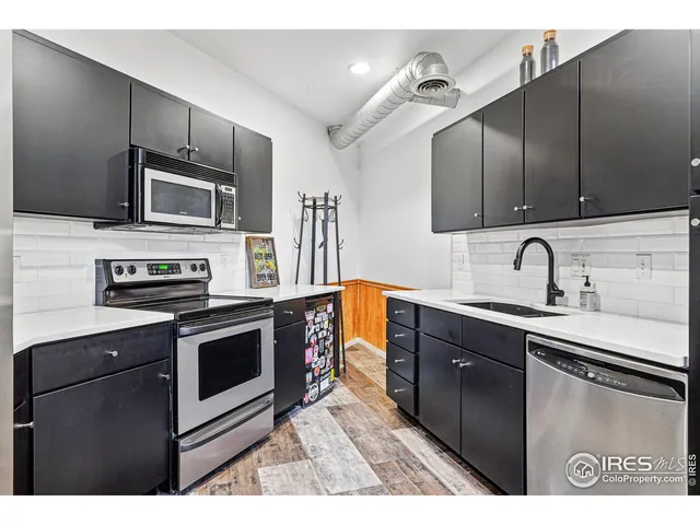 a kitchen with stainless steel appliances granite countertop a sink stove and microwave