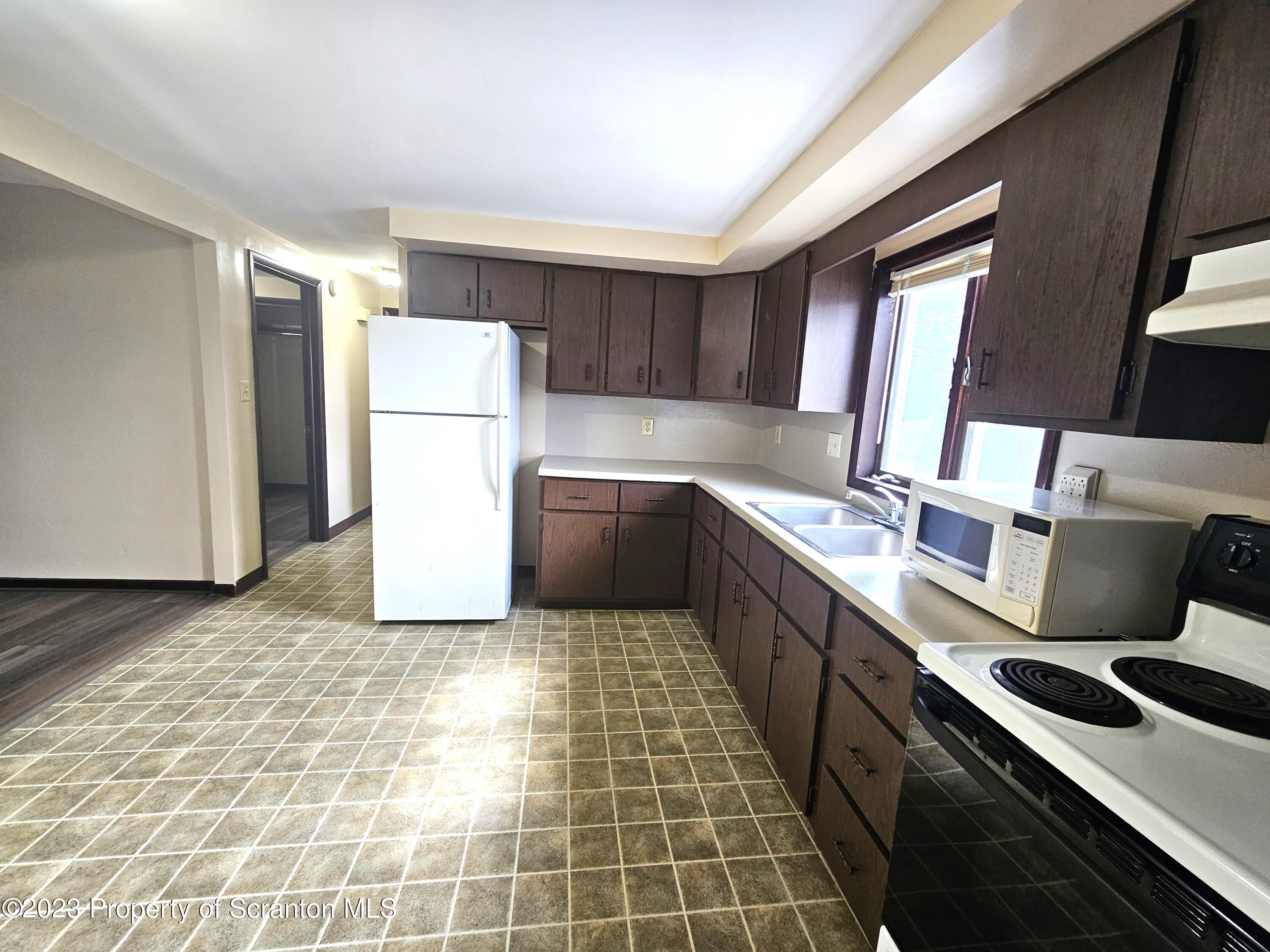 526 Hughes Court Scranton, PA 18504 - Photo 2 of 8 a kitchen with a sink a stove and a refrigerator