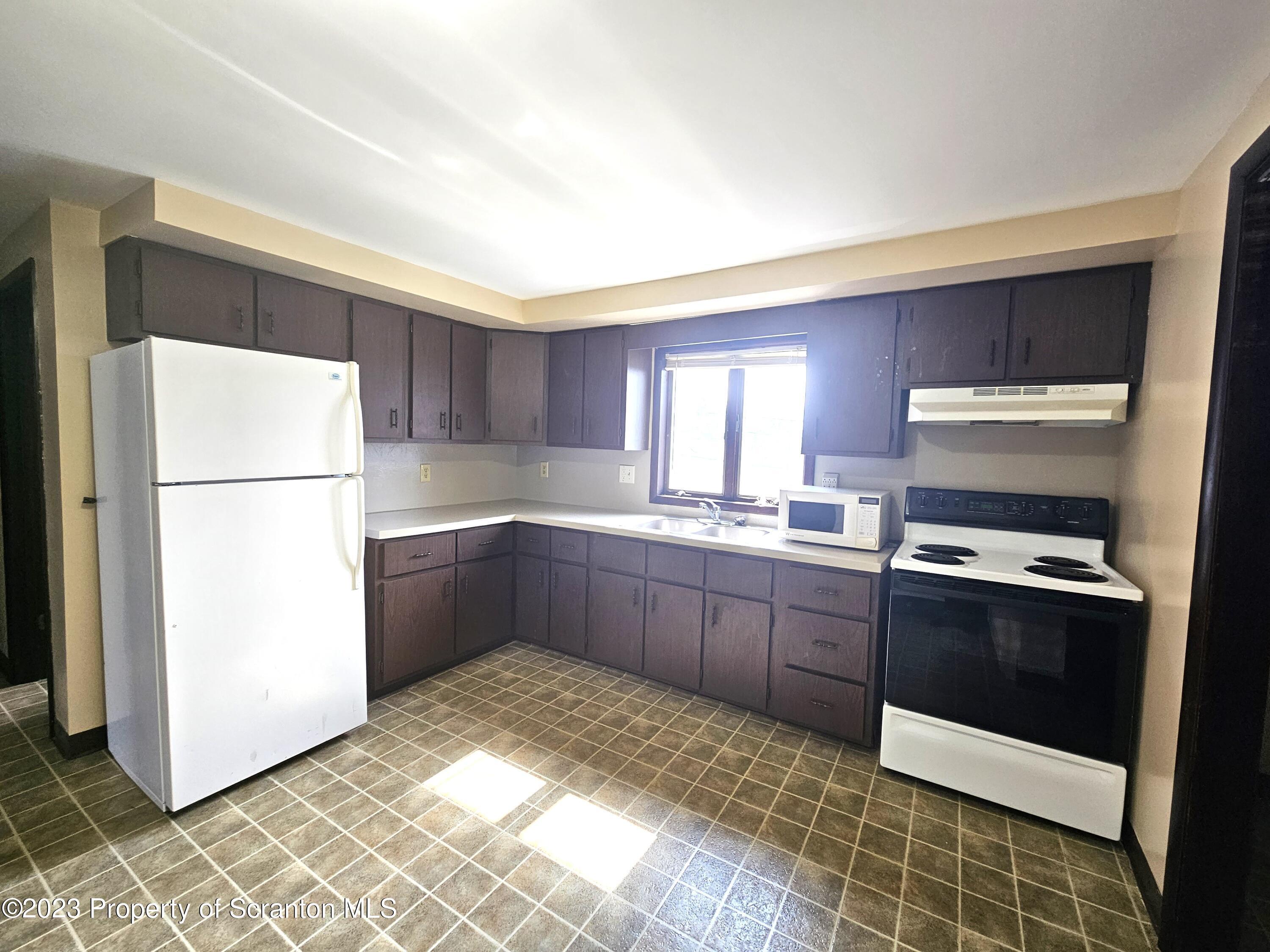 526 Hughes Court Scranton, PA 18504 - Photo 3 of 8 a kitchen with a refrigerator sink and cabinets